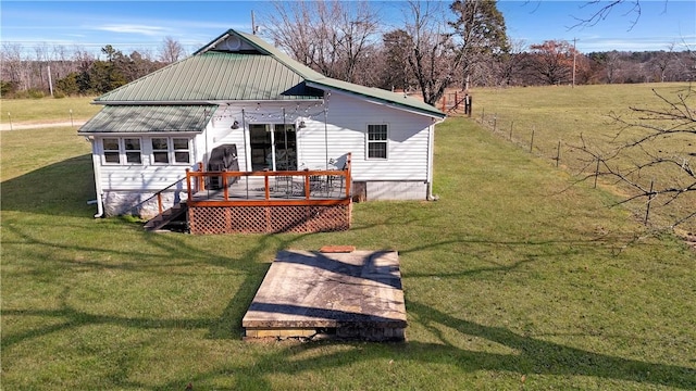 rear view of house featuring a lawn and a deck