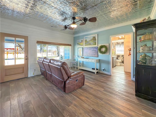 living room featuring hardwood / wood-style flooring, ceiling fan, and crown molding