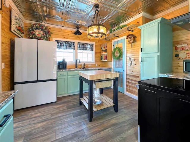 kitchen with wooden walls, dark hardwood / wood-style floors, and white refrigerator