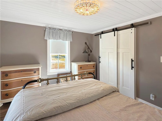 bedroom featuring a barn door, crown molding, and wood ceiling