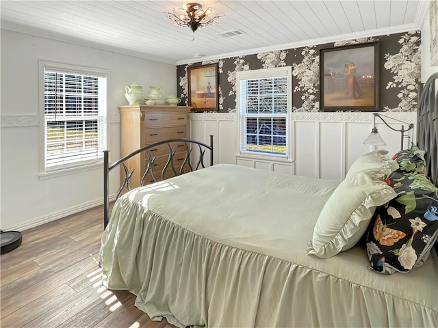 bedroom featuring hardwood / wood-style flooring, wood ceiling, and ornamental molding