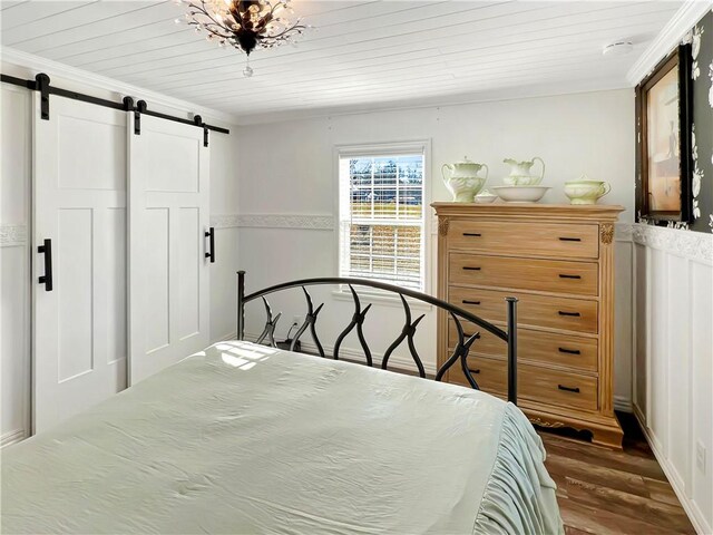 bedroom with a barn door, crown molding, dark hardwood / wood-style flooring, and wood ceiling