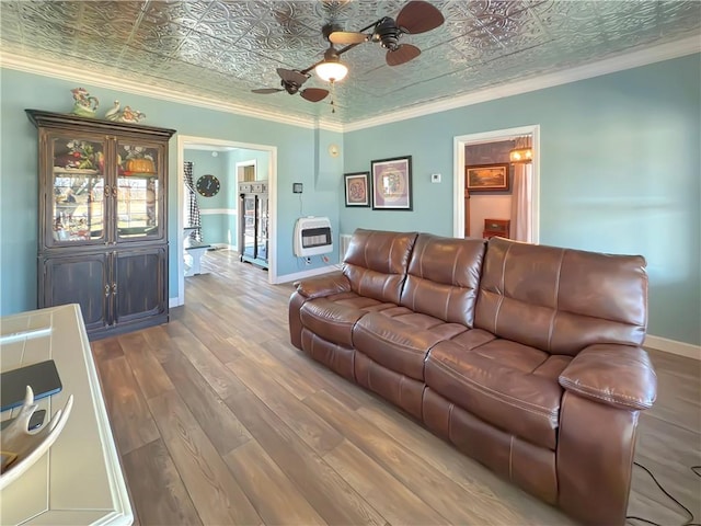 living room featuring heating unit, ceiling fan, crown molding, and wood-type flooring