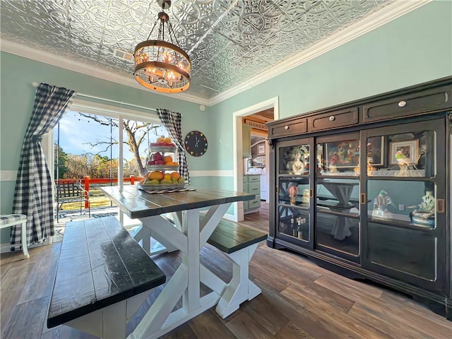 dining area featuring a notable chandelier, crown molding, and dark wood-type flooring