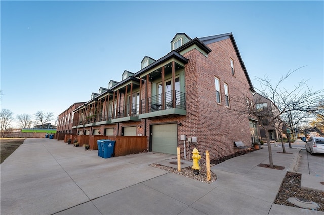 view of property exterior featuring a balcony and a garage