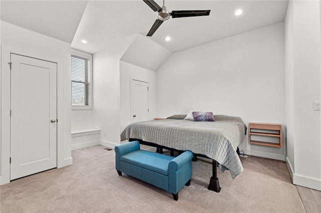 bedroom featuring ceiling fan, light colored carpet, and vaulted ceiling