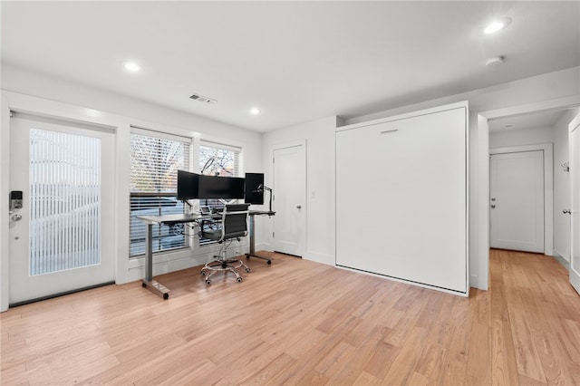 home office with light hardwood / wood-style flooring