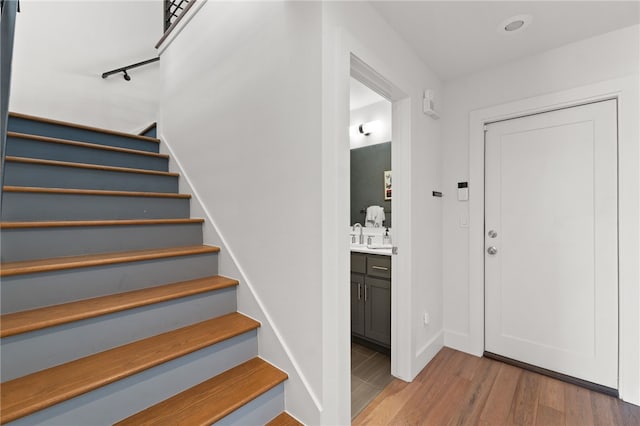 stairway with baseboards and wood finished floors