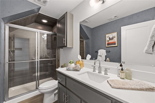 full bathroom with a stall shower, visible vents, vanity, and toilet