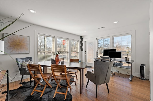 dining room with recessed lighting, plenty of natural light, and wood finished floors