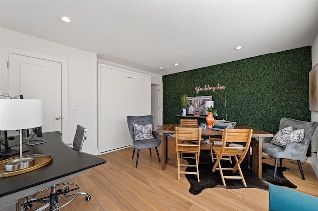 dining area with an accent wall, wood finished floors, wallpapered walls, and recessed lighting