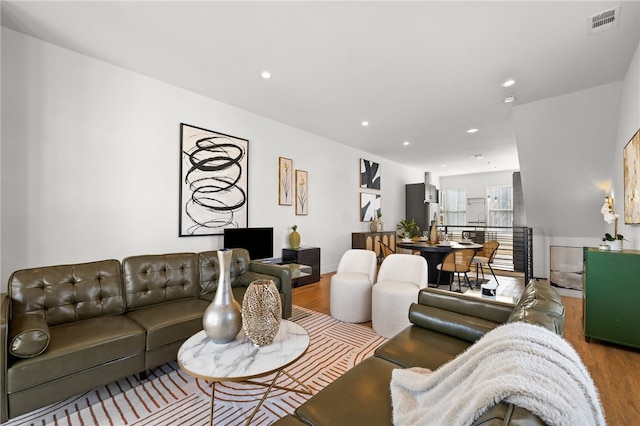 living room with visible vents, wood finished floors, and recessed lighting