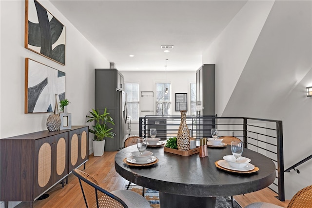 dining room with light wood-style floors and visible vents