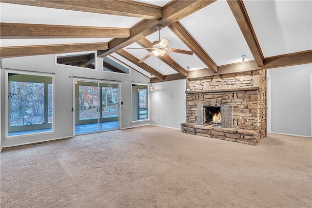 unfurnished living room featuring beam ceiling, ceiling fan, a fireplace, and carpet floors