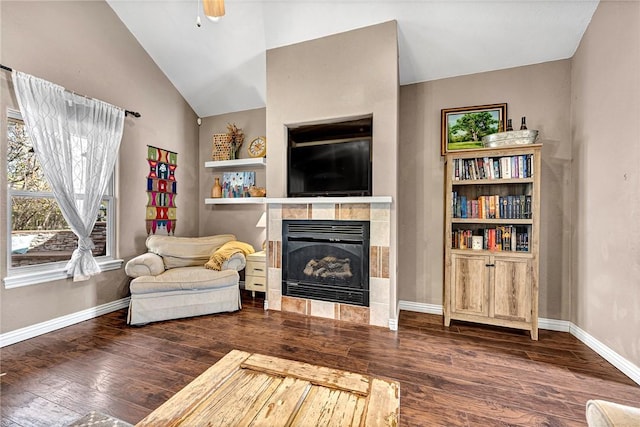 sitting room featuring lofted ceiling, ceiling fan, dark wood-type flooring, and a tiled fireplace