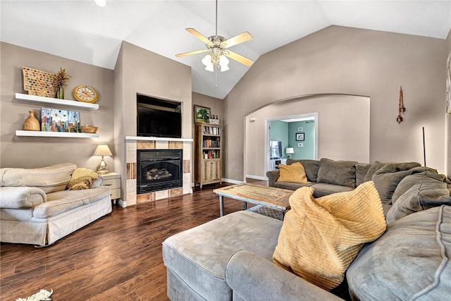 living room with a fireplace, vaulted ceiling, ceiling fan, and dark wood-type flooring