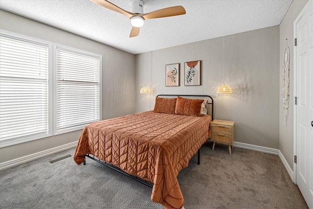 bedroom with ceiling fan, carpet, and a textured ceiling