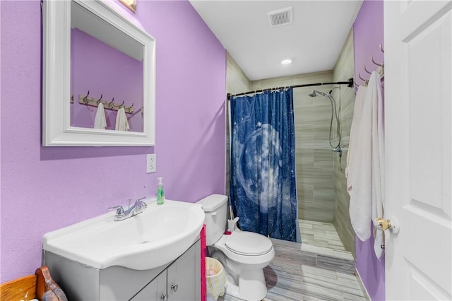 bathroom featuring a shower with shower curtain, vanity, and toilet