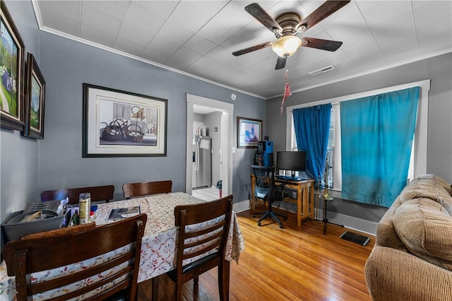 dining area featuring wood-type flooring, ceiling fan, and ornamental molding