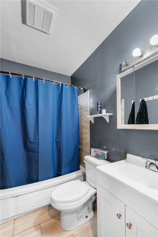 full bathroom featuring shower / bath combo with shower curtain, vanity, and toilet