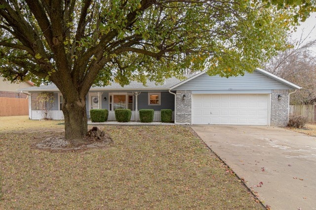 ranch-style home featuring a front lawn and a garage