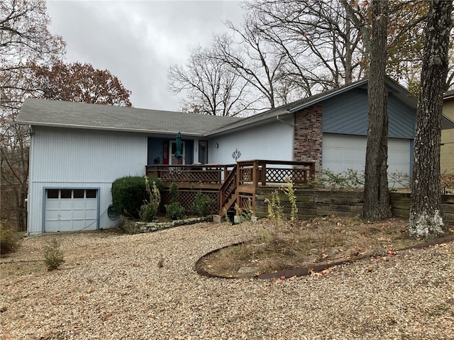 single story home featuring a deck and a garage