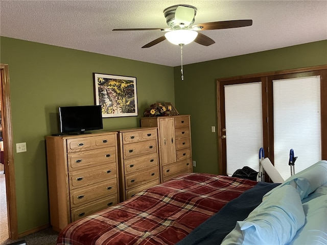 carpeted bedroom featuring ceiling fan and a textured ceiling