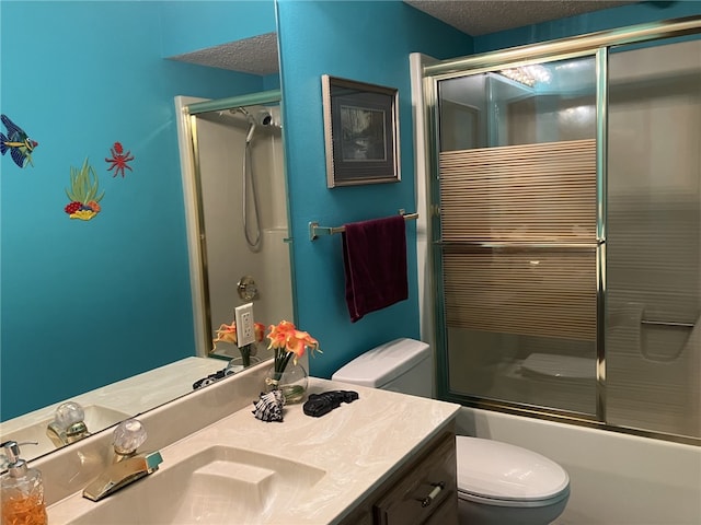 full bathroom with vanity, bath / shower combo with glass door, a textured ceiling, and toilet