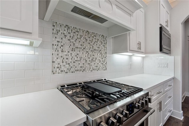 kitchen featuring stainless steel range, backsplash, dark hardwood / wood-style floors, and white cabinets