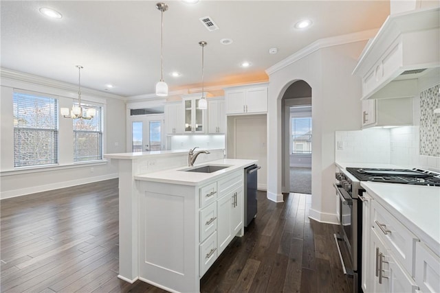 kitchen with a kitchen island with sink, sink, hanging light fixtures, white cabinetry, and stainless steel appliances