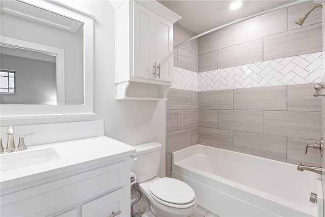 full bathroom featuring vanity, tiled shower / bath combo, and toilet