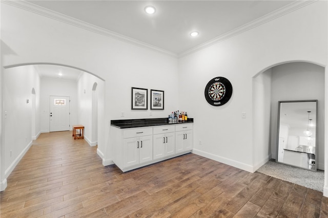 corridor featuring crown molding and light hardwood / wood-style flooring