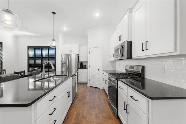 kitchen with white cabinets, decorative light fixtures, and stainless steel appliances