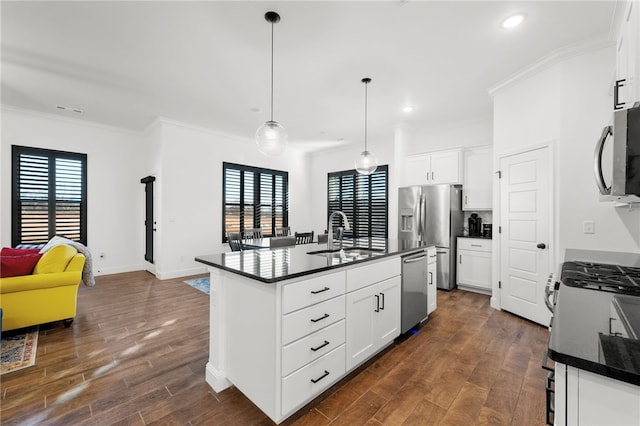 kitchen with sink, dark hardwood / wood-style floors, an island with sink, white cabinets, and appliances with stainless steel finishes