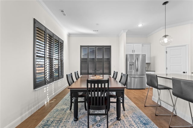 dining space featuring dark hardwood / wood-style floors and ornamental molding