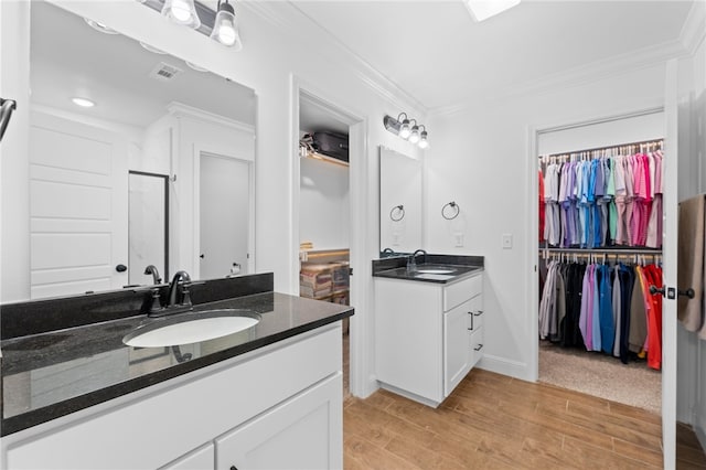 bathroom with a shower, crown molding, vanity, and hardwood / wood-style flooring