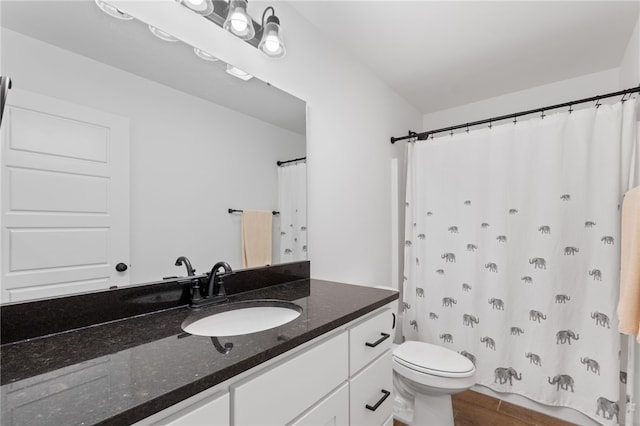 bathroom with vanity, hardwood / wood-style flooring, and toilet