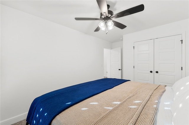 unfurnished bedroom featuring carpet floors, a closet, and ceiling fan