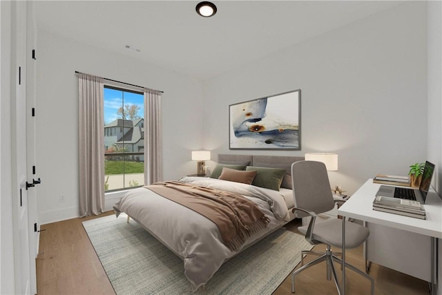 bedroom with visible vents, light wood-style flooring, and baseboards