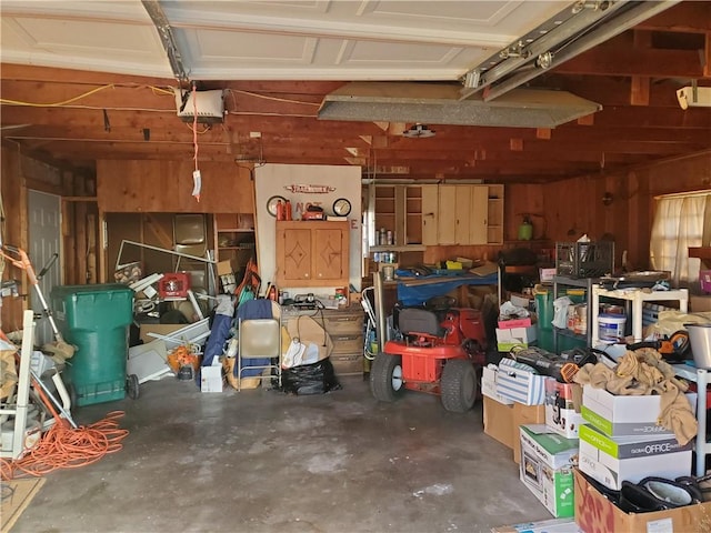 garage featuring a garage door opener and wooden walls