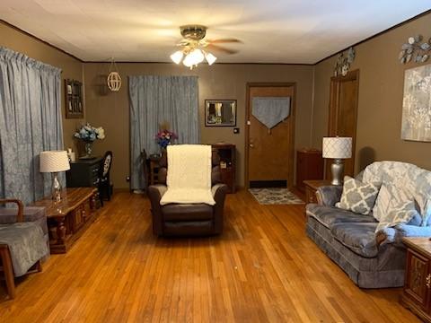 living area featuring light hardwood / wood-style floors and ceiling fan