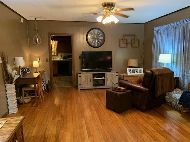 living room featuring hardwood / wood-style floors and ceiling fan