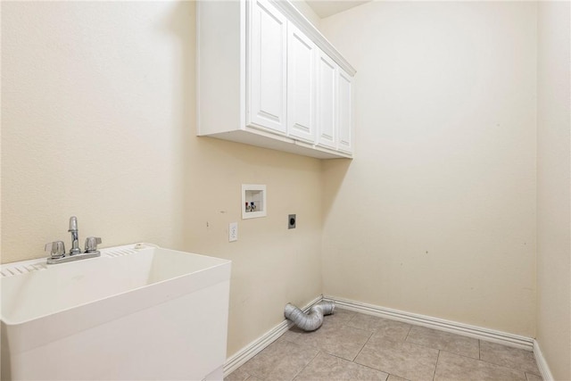 clothes washing area featuring hookup for an electric dryer, hookup for a washing machine, cabinets, sink, and light tile patterned floors