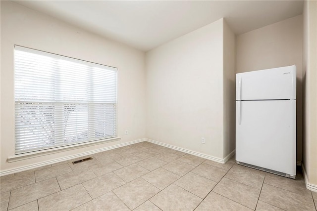 kitchen featuring white refrigerator and light tile patterned flooring