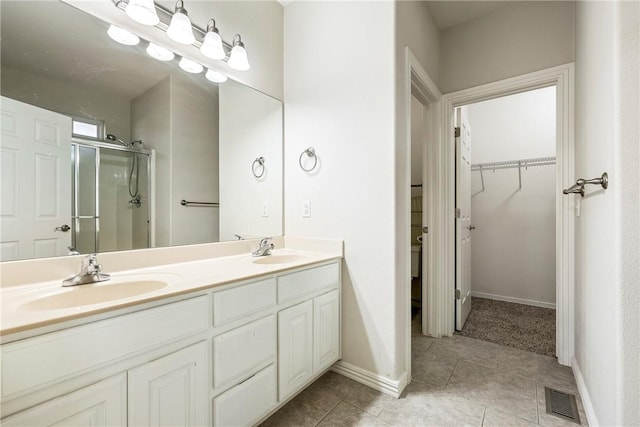 bathroom with tile patterned flooring, vanity, and an enclosed shower