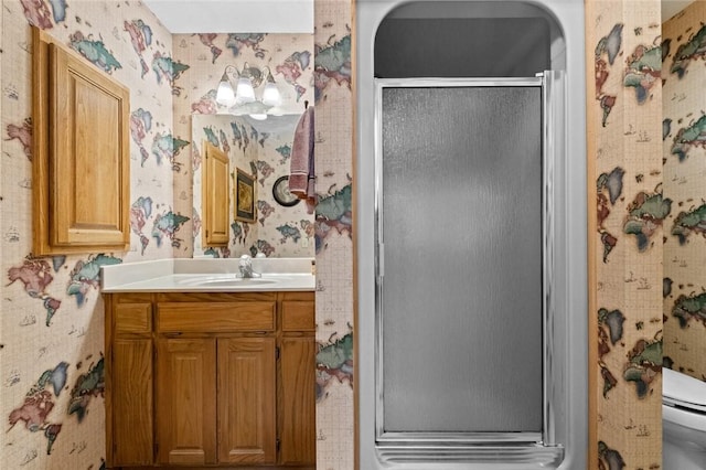 bathroom with a shower with door, vanity, and toilet