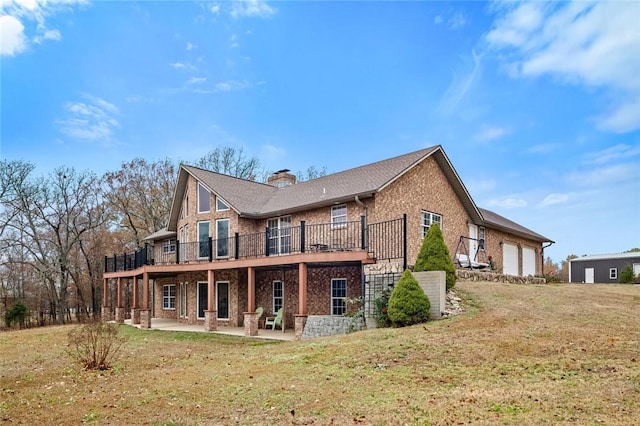 back of house featuring a patio area, a yard, and a garage