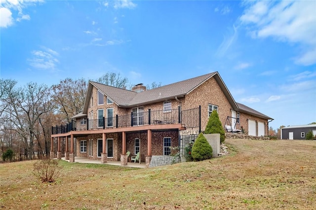 15262 Shipe Rd, Gravette, AR 72736 - back of property featuring brick siding, a garage, a patio area, and a yard