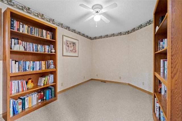 carpeted empty room featuring built in features and ceiling fan