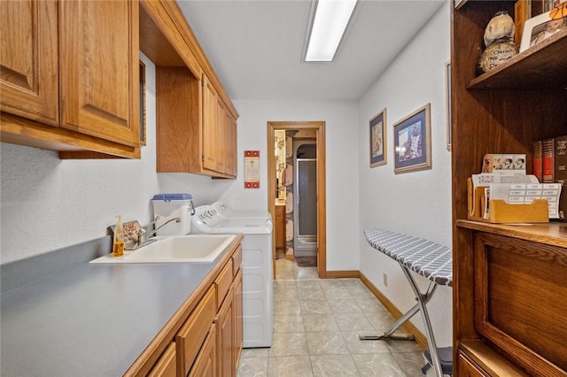 laundry room with cabinets, independent washer and dryer, light tile patterned floors, and sink